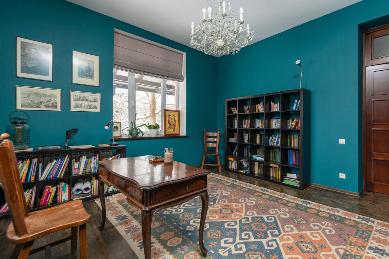 testimonials-img Charming vintage-style study room featuring blue walls, wooden furniture, and a classic chandelier.